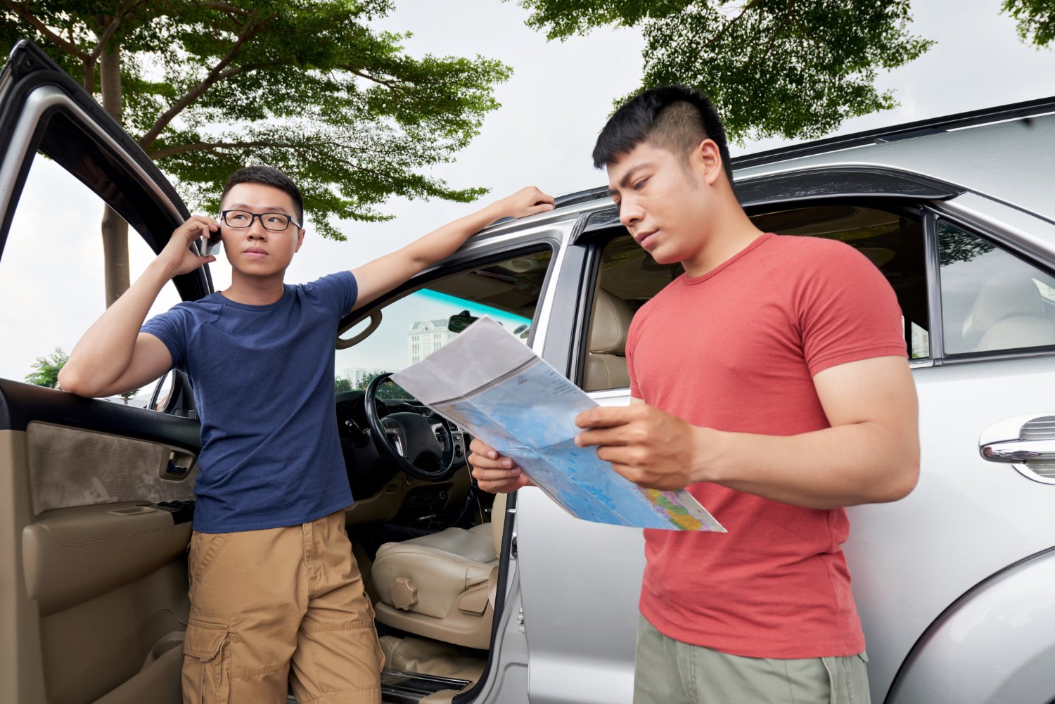 2 men stand near a car